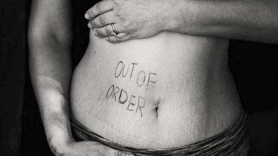 person with the words "out of order" written on belly