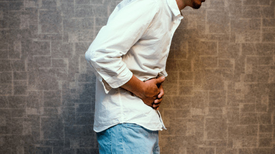 man clutching stomach in pain